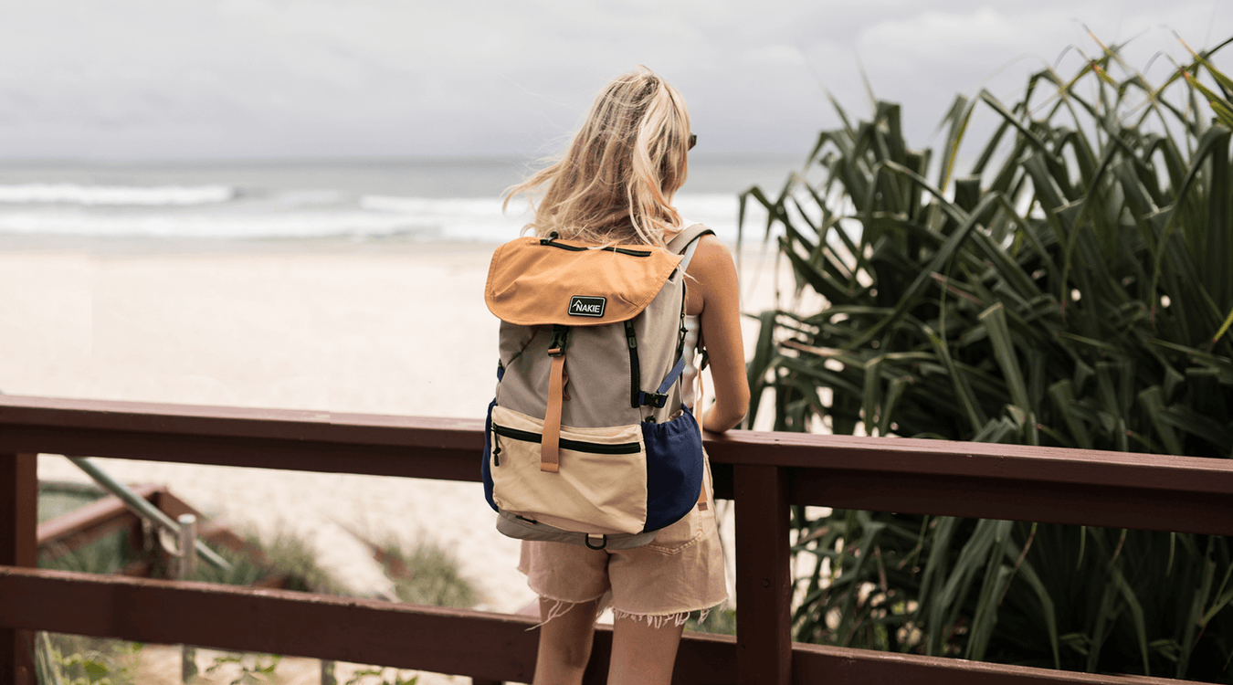 Man hiking in forest with sustainable Nakie backpack made from recycled plastic bottles, ideal eco-friendly hiking gear