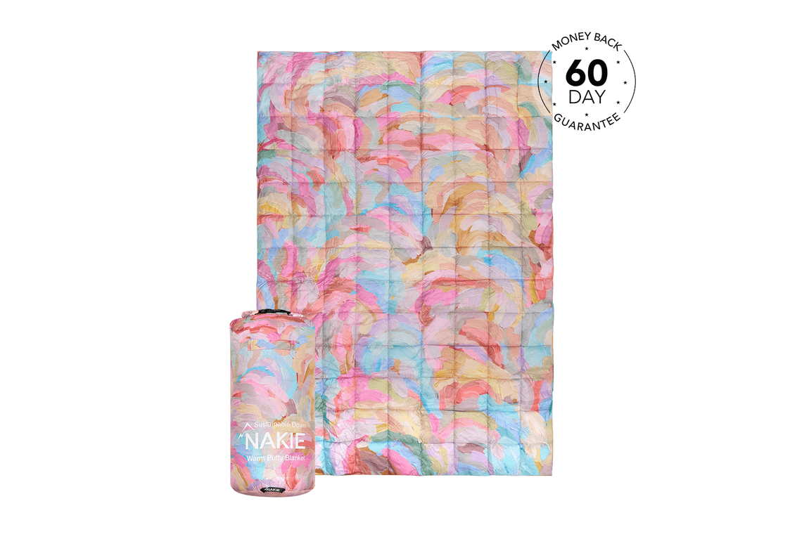 Multicoloured watercolour patterned sustainable down puffy blanket by Nakie, shown flat and rolled with stuff sack.