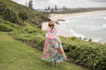 Multicolored quilted down puffy blanket with pastel patchwork pattern, draped around woman outdoors by beach preview #8