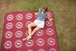 Red recycled picnic blanket with white Ringers Western logo pattern, displayed flat on grass preview #9