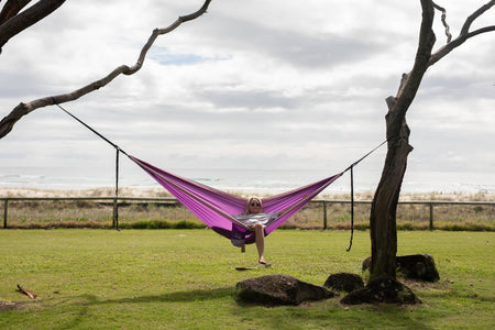 Purple Nakie hammock in a studio, emphasizing its recycled plastic bottle construction and portable design